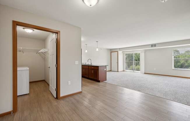 an open living room and kitchen with wood floors and white walls