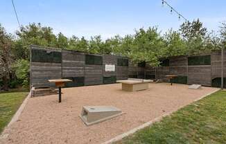 A backyard with a sandbox and a wooden fence.