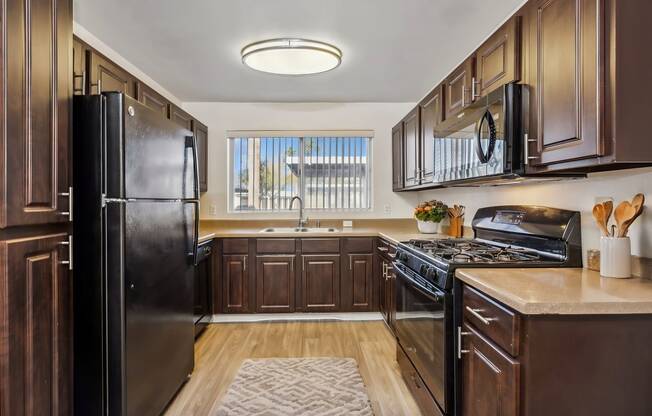 a kitchen with black appliances and wooden cabinets