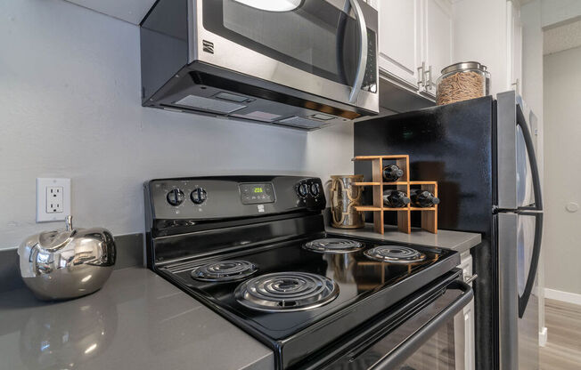 a kitchen with a stove and a microwave at Sunnyvale Crossings Apartments, LLC, Sunnyvale