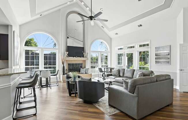A modern living room with a grey sofa and a bar area.