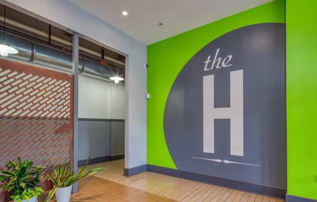 a large green and grey logo on a grey wall in an office