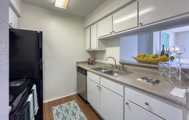 a kitchen with white cabinets and a sink and a refrigerator