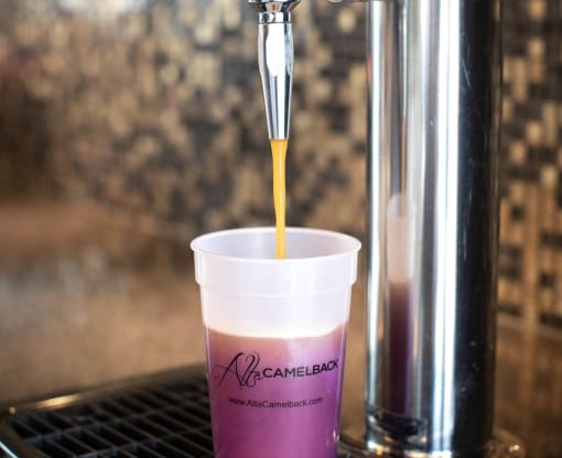 a cup of coffee being poured from a coffee maker