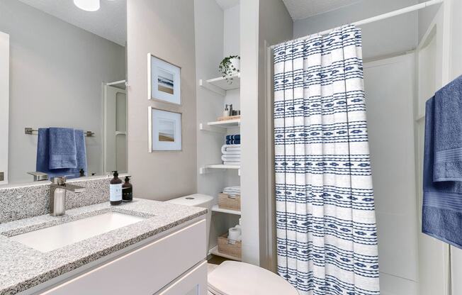 a bathroom with a shower and a sink and a toilet