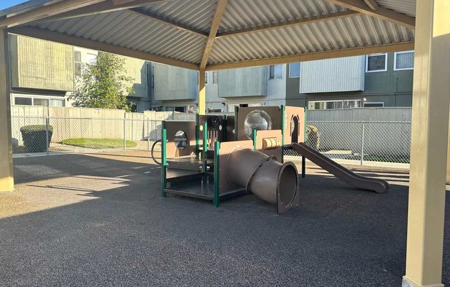 A playground with a slide and a seesaw.