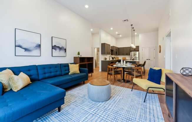 a living room with a blue couch and a table with chairs