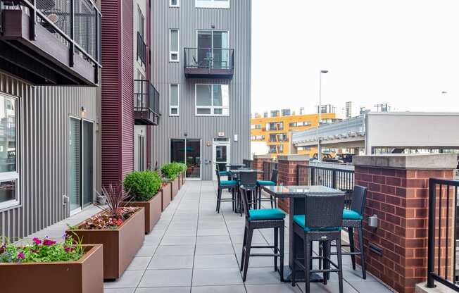 an outdoor patio with tables and chairs at the melrose apartments