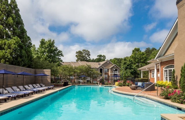 View of Pool Area, Showing Fenced-In Area, Loungers, and Umbrellas at Retreat at Peachtree City Apartments
