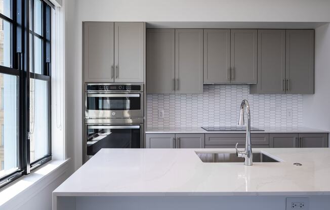 a kitchen with white counter tops and stainless steel appliances  at The Belden Stratford, Chicago, Illinois