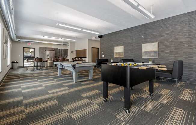 A billiard table is in the middle of a room with a carpeted floor.