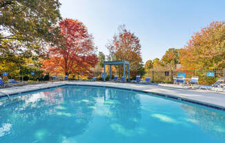 the swimming pool at our crossings apartments with a pool and chairs