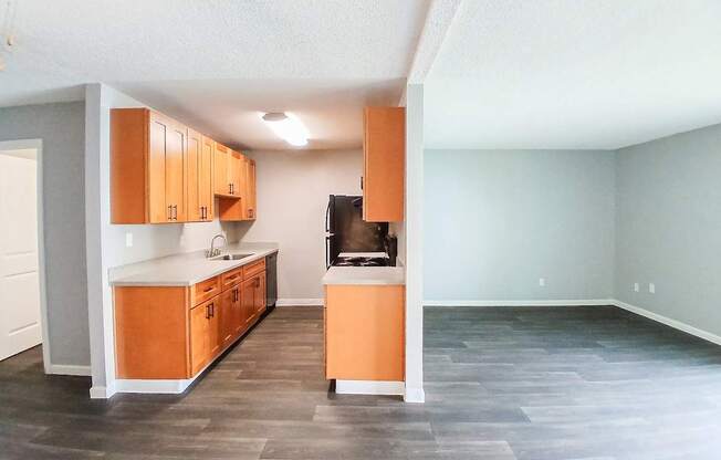 A kitchen with wooden cabinets and a black fridge.