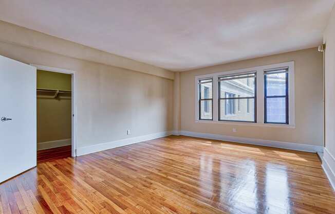 an empty living room with wood floors and a door to a closet