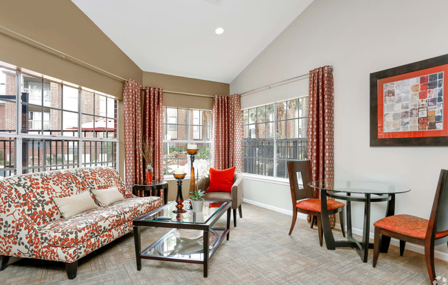 a living room with a couch and a table and windows