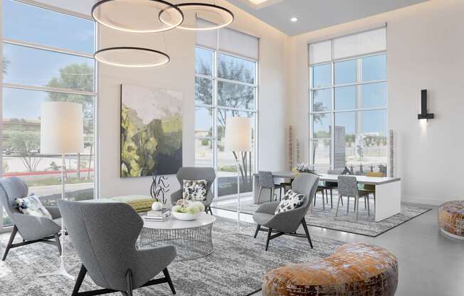 A modern living room with grey chairs and a large window.