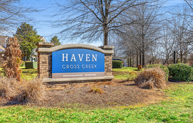 A sign that says Haven Cross Creek in front of a tree.
