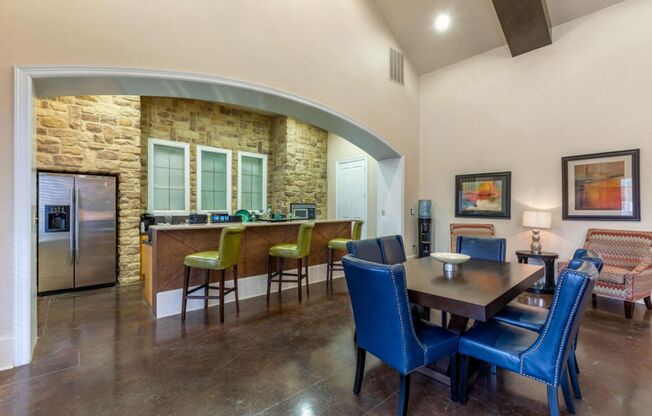 Clubhouse kitchen with a large wooden table, blue chair, and a kitchen island