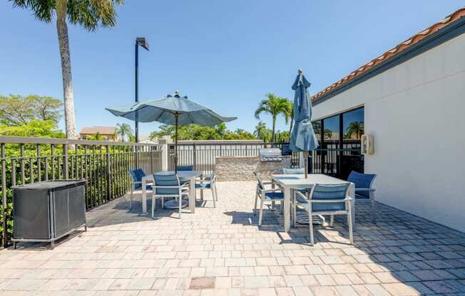 Coconut Creek Apartments – Waterview at Coconut Creek – patio with tables and chairs and umbrellas