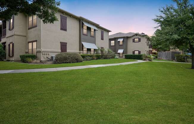 an image of an apartment complex with a green lawn
