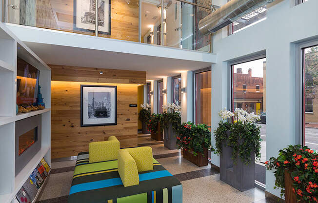 the lobby of a building with a colorful couch and plants at Ann Arbor City Club, Ann Arbor, 48104