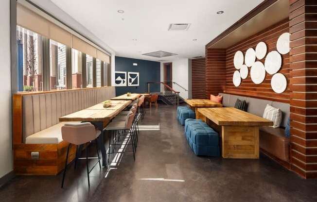 A long wooden table with chairs and a bench is in a room with a brick wall.