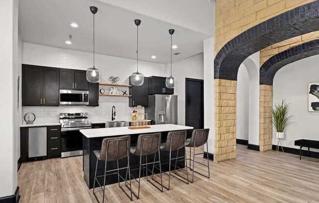 an open kitchen with a large island and black and white cabinets