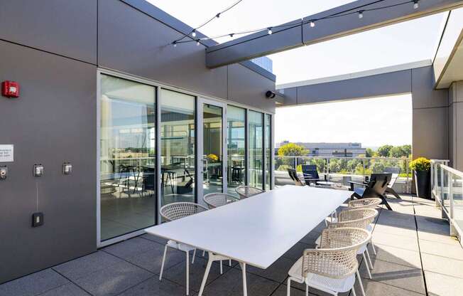 A white table with chairs is set up on a patio.