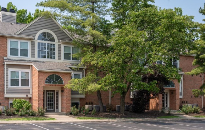 a large brick apartment complex with trees in front of it