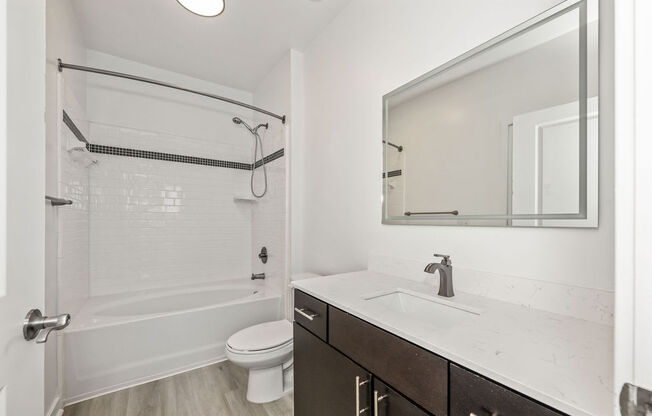 A white bathroom with a toilet, sink, and shower.