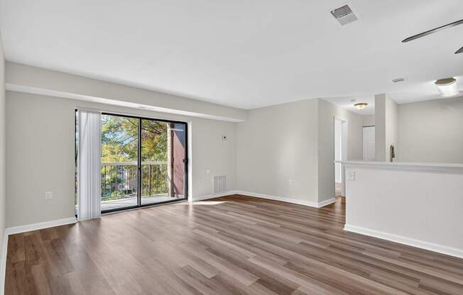 A room with wooden flooring and sliding glass doors.