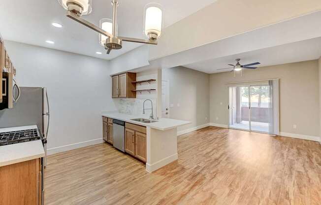 A kitchen with wooden floors and a ceiling fan.