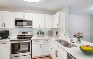 A kitchen with white cabinets and a stainless steel oven.