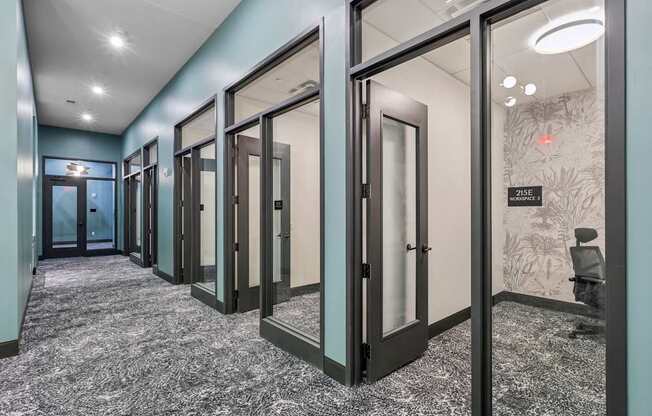 A hallway with glass doors and a carpeted floor.