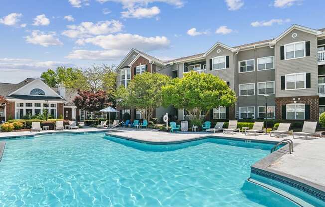 A large swimming pool in front of apartment buildings.
