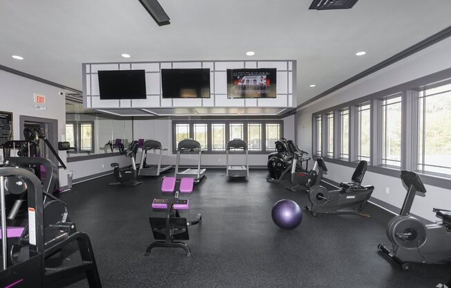 a gym with exercise equipment and windows in a building