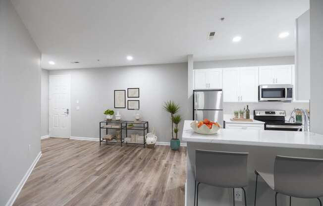 an open kitchen and living room with a large island and stainless steel appliances