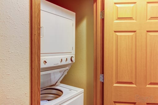 a bathroom with a toilet and a washer and dryer