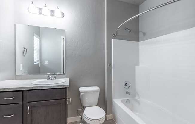 A white bathroom with a toilet, sink, and bathtub.