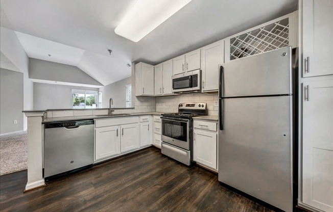 a kitchen with stainless steel appliances and white cabinets