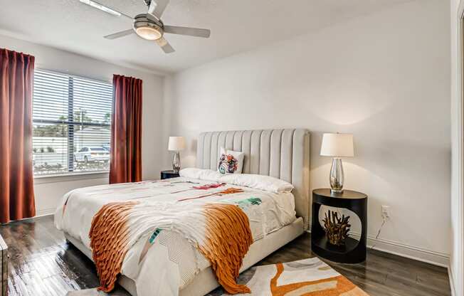 Bedroom with wood-designed flooring, window, and ceiling fan at EOS in Orlando, FL