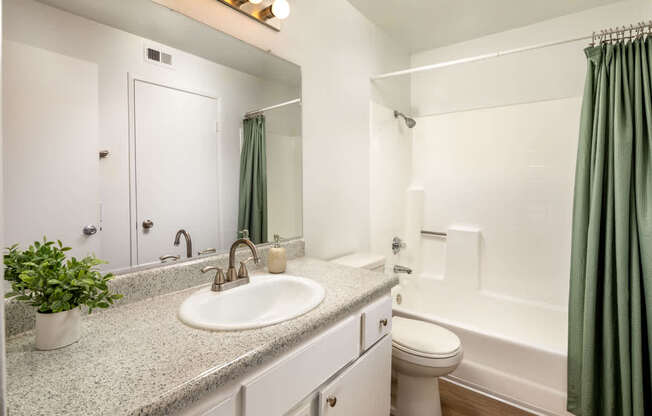 A bathroom with a sink, toilet, and bathtub.