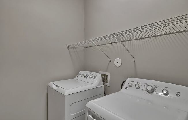 an empty laundry room with two washes and a dryer at Nexus at Sandhill, Columbia, SC 29229 