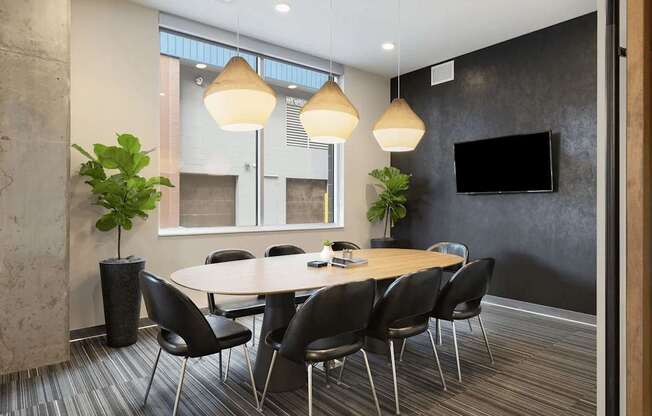 A conference room with a large table surrounded by chairs.