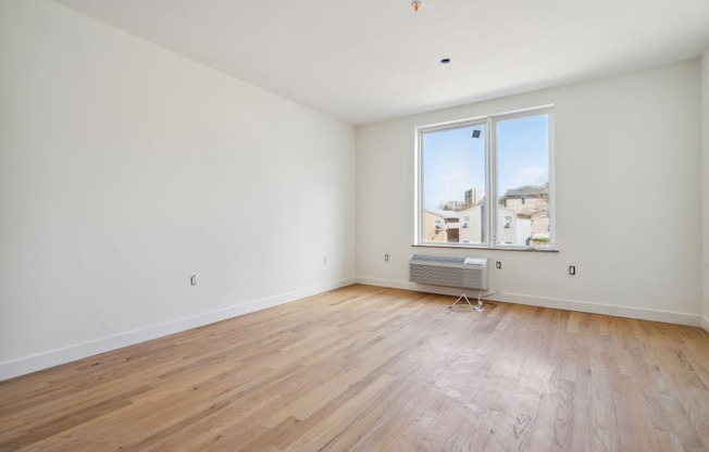 a living room with wood floors and a large window