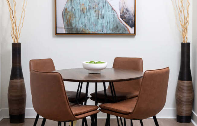 A modern dining room with a round table and chairs.