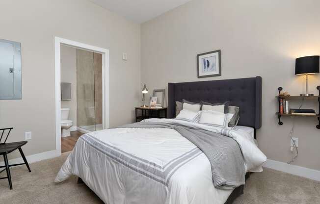 a bedroom with a large bed and a bathroom with a shower at Hayden Lofts, Ohio