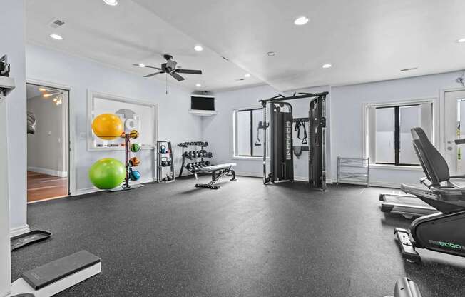 A spacious home gym with a variety of equipment including a treadmill, weights, and a bench press.