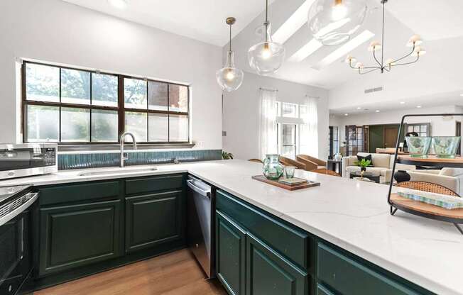 A kitchen with green cabinets and a white countertop.