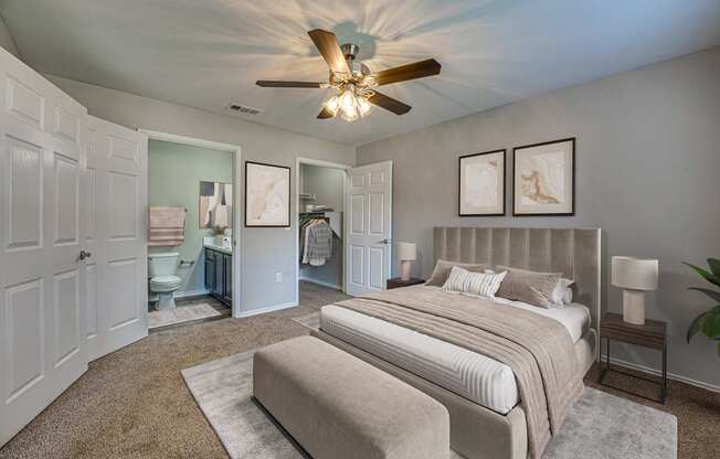 A bedroom with a large bed and a ceiling fan.